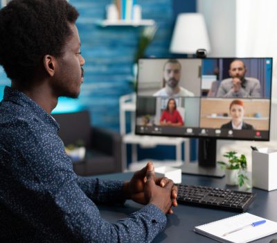Man of african ethnicity using conference webcam communication to connect via internet with coworkers while working from home. Black person remote worker chatting about job duties